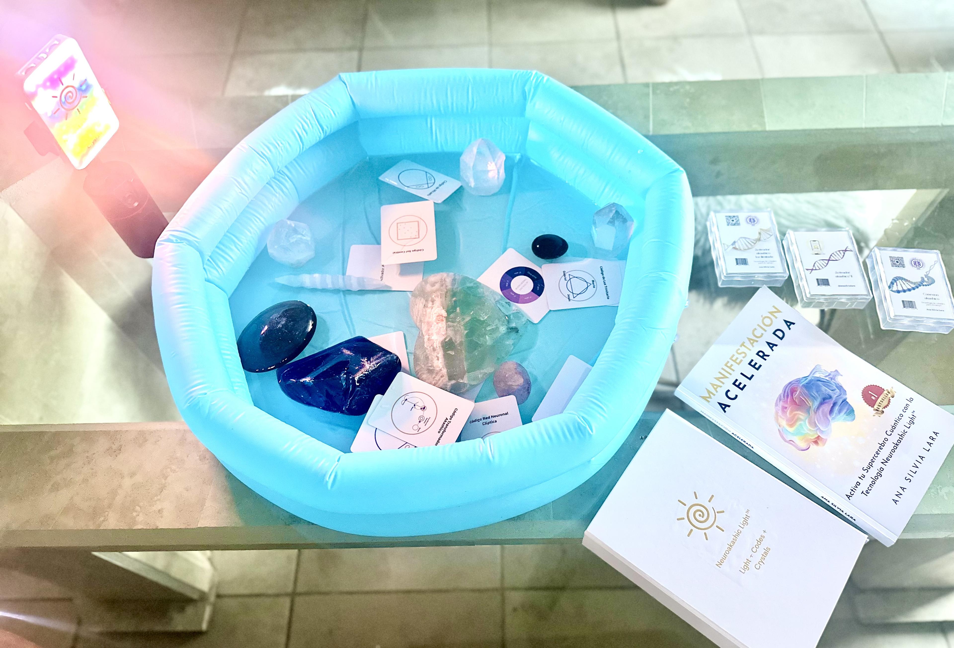 Neuroakashic Light™ setup with turquoise crystal water bowl, sacred codes, crystals, and Ana Silvia's book